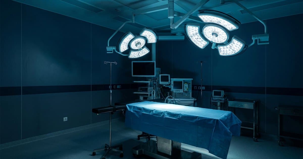 An empty hospital operating room with overhead surgical lights